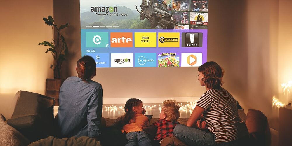 Projektor ACER AOpen QF18S YouTube Netflix streaming aplikacje, rodzina siedząca na kanapie, obraz wyświetlany na ścianie