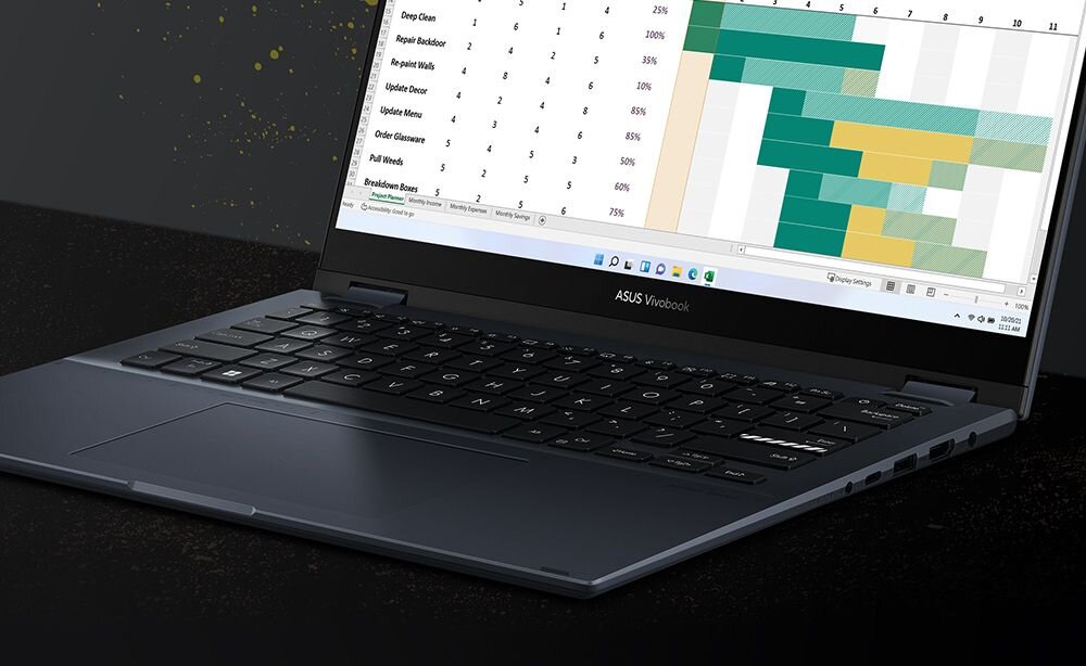 ASUS VivoBook S 14 Flip w widoku od góry z wykresem Gantta na ekranie w ciemnym otoczeniu, demonstrujący podświetlaną klawiaturę z klawiszami funkcyjnymi F7 (Fn+F7) do sterowania jasnością podświetlenia dla pracy w każdych warunkach - Klawiatura ASUS ErgoSense