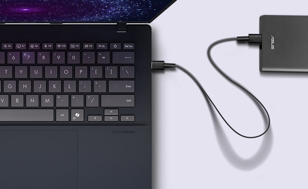 Laptop ASUS VivoBook 14 z widocznym portem USB-C połączonym kablem z zewnętrzną ładowarką ASUS demonstrującym funkcję Power Delivery na białym tle - ładowanie przez USB-C