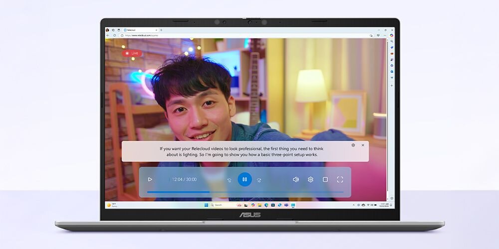 Laptop ASUS VivoBook 14 z funkcją Live Captions wyświetlający film z młodym mężczyzną oraz napisy na żywo z tłumaczeniem na angielski w czasie rzeczywistym - Funkcja automatycznych napisów na żywo