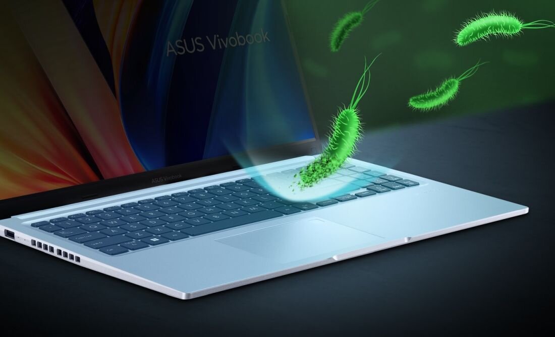 Laptop ASUS VivoBook pokazany z wizualizacją mikroorganizmów nad klawiaturą ilustruje działanie powłoki Antibacterial Guard – ASUS Antibacterial Guard