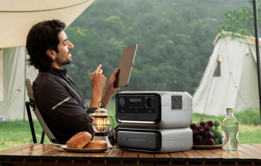 Stacja zasilania ECOFLOW River 3 Max 572 Wh Bank energii, Bank energii pod ręką, Mężczyzna pod namiotem pije kawę, na 1 planie bank energii