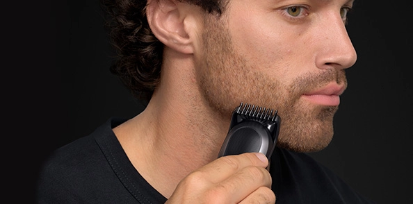 Mężczyzna w czarnej koszuli z uśmiechem na twarzy.