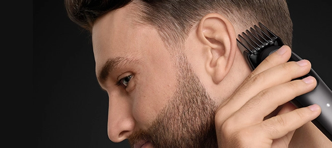 Mężczyzna w czarnej koszuli z uśmiechem na twarzy.