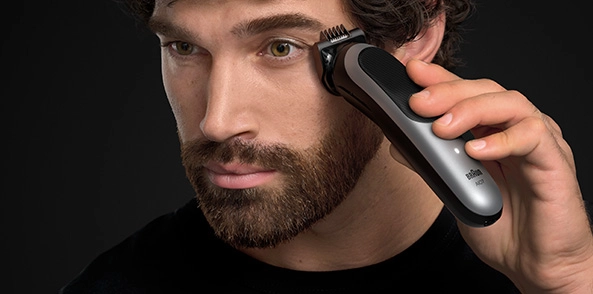 Mężczyzna w czarnej koszuli z uśmiechem na twarzy.