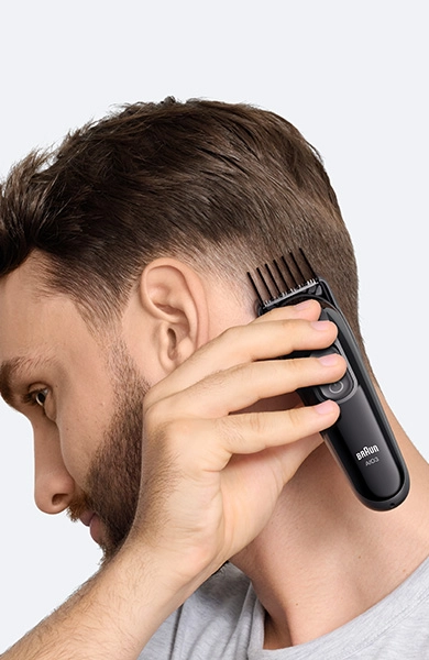 Mężczyzna w czarnej koszuli z uśmiechem na twarzy.