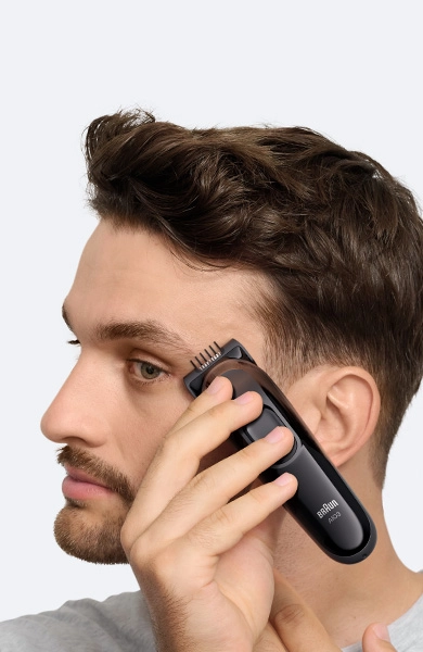 Mężczyzna w czarnej koszuli z uśmiechem na twarzy.