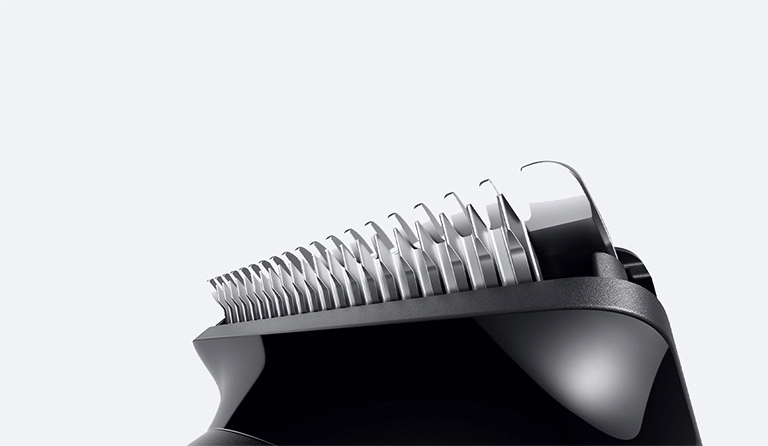 Mężczyzna w czarnej koszuli z uśmiechem na twarzy.