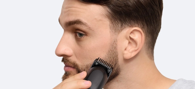 Mężczyzna w czarnej koszuli z uśmiechem na twarzy.