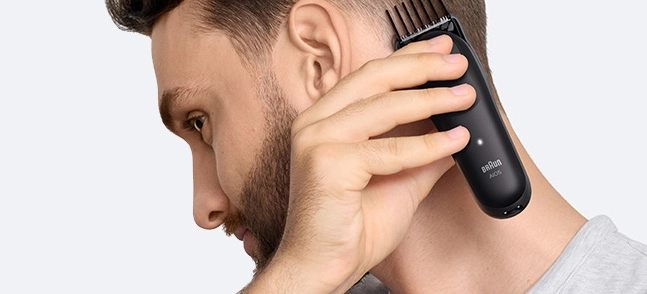 Mężczyzna w czarnej koszuli z uśmiechem na twarzy.