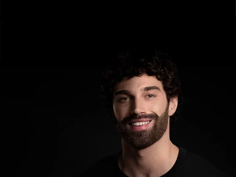 Mężczyzna uśmiecha się po goleniu, wyrażając radość i zadowolenie.