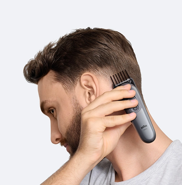 Mężczyzna w czarnej koszuli z uśmiechem na twarzy.