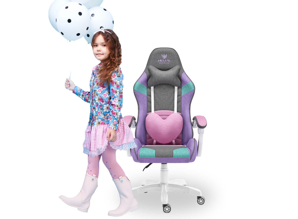 Na obrazie widoczny jest fotel gamingowy w kolorach szaro-fioletowym z różowym poduszką w kształcie serca oraz logo \'HELL\'S CHAIR\' na zagłówku. Obok stoi dziecko trzymające balony w kolorze białym z czarnymi kropkami.