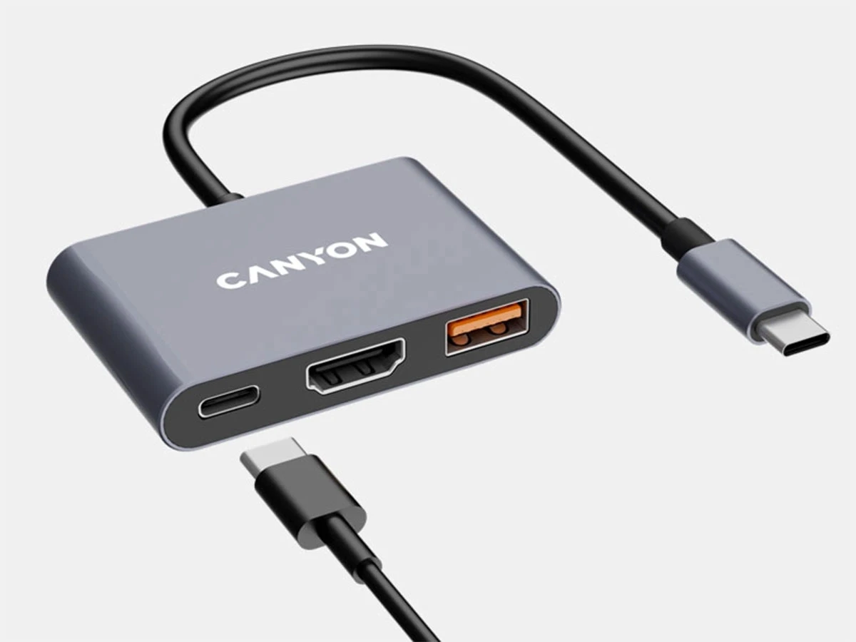 Szary hub USB-C z trzema portami: USB-C, HDMI i USB-A. Na urządzeniu widoczne jest logo \'CANYON\'.