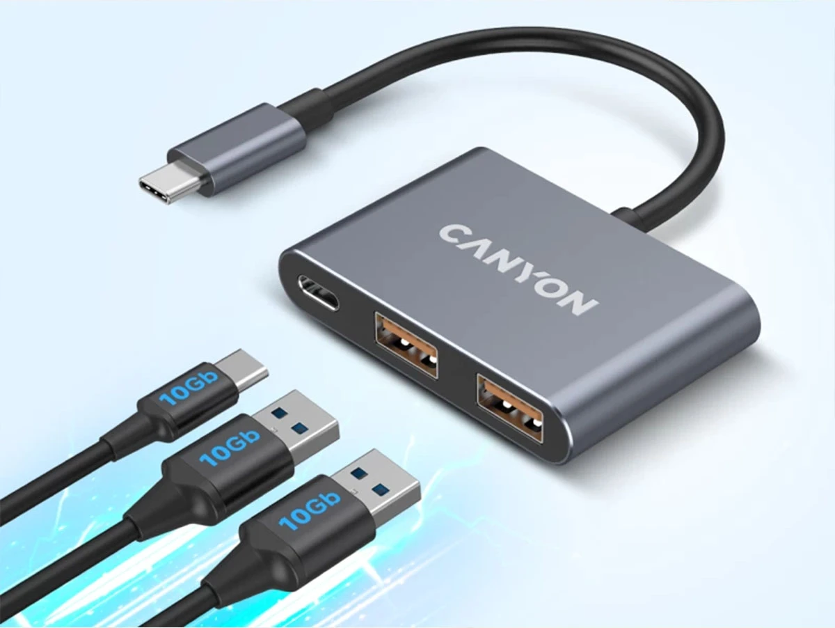 Na obrazie widoczny jest ciemnoszary hub USB-C z logo \'CANYON\', posiadający dwa porty USB oraz jeden port USB-C. Obok znajdują się trzy kable z oznaczeniem \'10Gb\'.