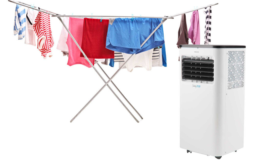 Na obrazie widoczny jest klimatyzator z napisem \'Cooling 3.0\' obok stojaka z rozwieszonymi ubraniami. Klimatyzator ma białą obudowę z czarnym panelem na górze.