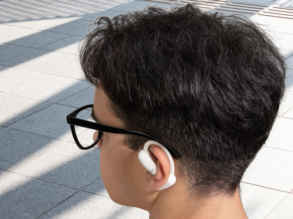 Słuchawki powietrzne SOUNDCORE AeroFit 2 tłumaczenie w czasie rzeczywistym aplikacja soundcore, osoba na świeżym powietrzu z założonymi słuchawkami