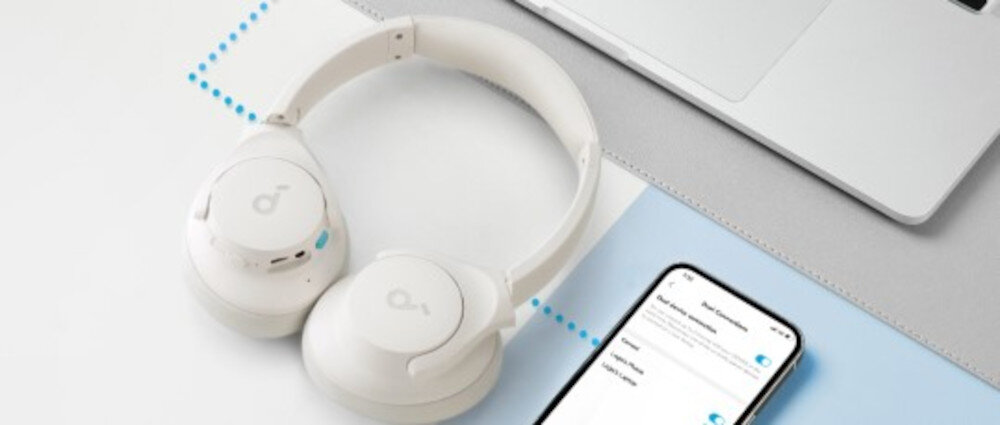 Słuchawki nauszne SOUNDCORE Q11i do 60h pracy szybkie ładowanie 5 minut długie słuchanie Bluetooth, słuchawki nauszne leżące na biurku obok smartfona