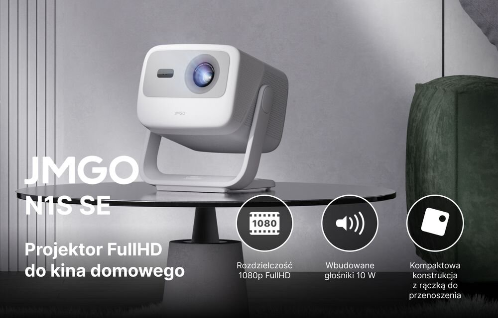Na obrazie znajduje się projektor JMGO N1S SE umieszczony na okrągłym stoliku. Widoczny jest tekst: \'JMGO N1S SE Projektor FullHD do kina domowego\', \'Rozdzielczość 1080p FullHD\', \'Wbudowane głośniki 10 W\', \'Kompaktowa konstrukcja z rączką do przenoszenia\'.
