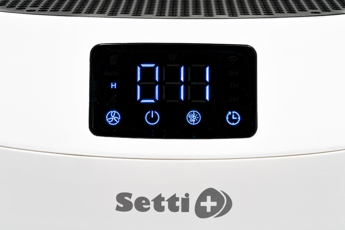 Oczyszczacz powietrza SETTI+ AP650W Wi‑Fi Zbliżenie na cyfrowy panel sterowania białego oczyszczacza powietrza Setti+. Wyświetlacz świeci na niebiesko, pokazując liczbę 014 (wskaźnik jakości powietrza PM 2.5) oraz ikony ustawień i trybu pracy, m.in. Auto, timer i jonizację/UV.