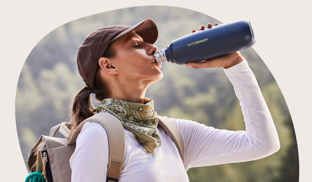 BUTELKA TERMICZNA SODASTREAM DO GAZOWANIA WODY STORM BLUE 0.9L kobieta pije napój z butelki w kolorze granatowym wytrzymały funkcjonalny sprawdza się w każdej sytuacji stylowy szczelność silikonowa uszczelka brak BPA wolna od bisfenoli stal nierdzewna 18/8 odporna na korozję wgniecenia i zarysowania czyszczenie mycie w zmywarce