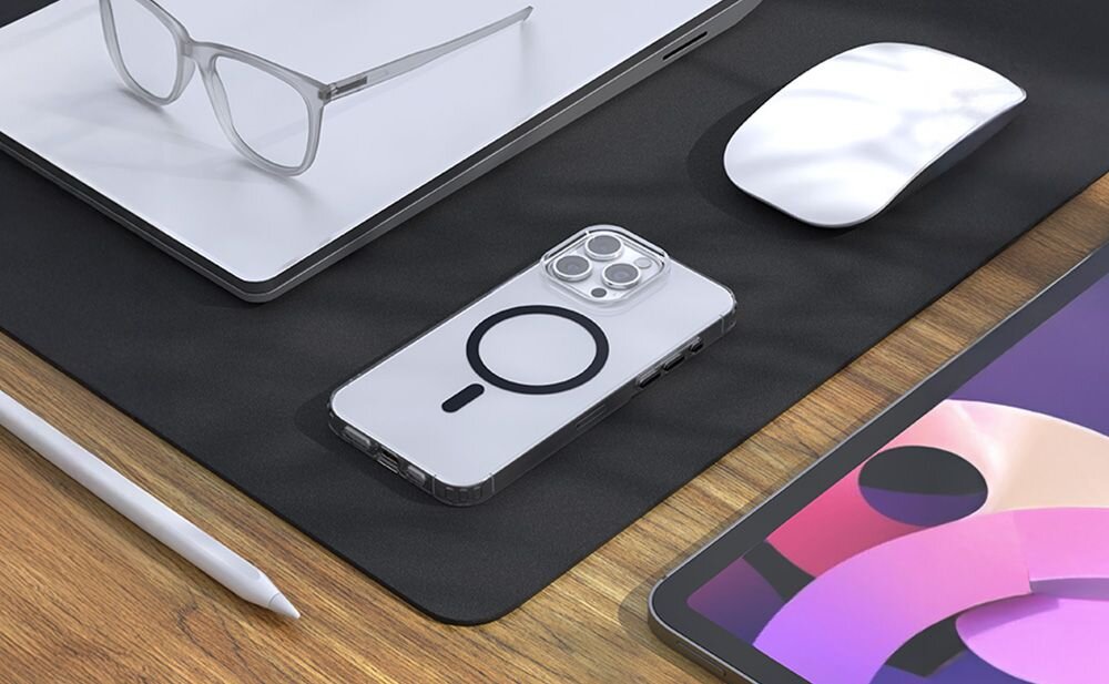 Na drewnianym biurku leży przezroczysto-czarne etui na telefon z widocznym okrągłym wzorem, obok laptopa, myszki, okularów i tabletu. Na biurku znajduje się również biały rysik.