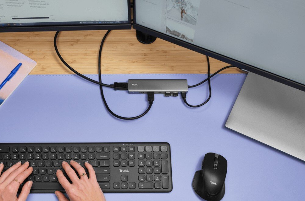 Hub TRUST Dalyx 25661 Widok z góry na stanowisko pracy z fioletową podkładką gdzie szary hub USB-C łączy klawiaturę i mysz z dwoma monitorami