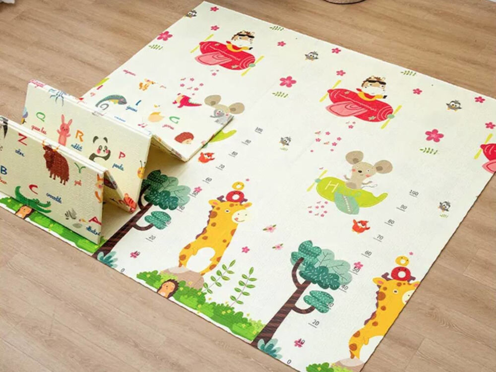 Mata piankowa EXTRALINK 4305 Składana 150 x 200 x 1 cm Składana piankowa mata edukacyjna dla dzieci rozłożona na podłodze, przedstawiająca kolorowe zwierzęta, żyrafę z miarką wzrostu oraz samoloty.