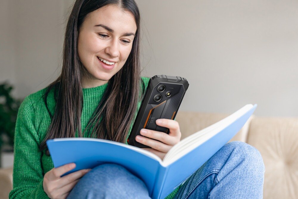 Smartfon OSCAL Marine 2 kobieta korzysta ze smartfona i książki   