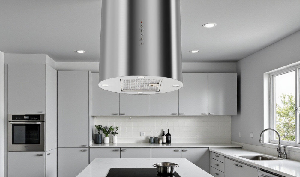 OKAP AKPO WK-4 Isla Balmera Slim Na zdjęciu widać przestronną kuchnię w ciemnej kolorystyce z dużym, czarnym okapem wyspowym zawieszonym nad wyspą kuchenną. W tle znajdują się długie blaty robocze, zabudowa z piekarnikiem, duże okna z widokiem na zieleń oraz dwa zlewy z wysokimi bateriami smukły design minimalistyczny elegancja styl industrialny proporcje