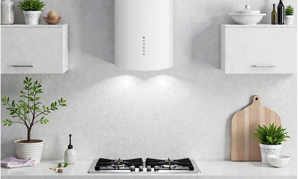 OKAP AKPO WK-4 Balmera WL Slim Nad płytą gazową zawieszony jest biały, cylindryczny okap, który oświetla blat dwoma punktami światła. Po bokach stoją szafki wiszące oraz rośliny i drewniana deska, tworząc spójną, jasną aranżację kuchni wygląd detale styl kolor biały