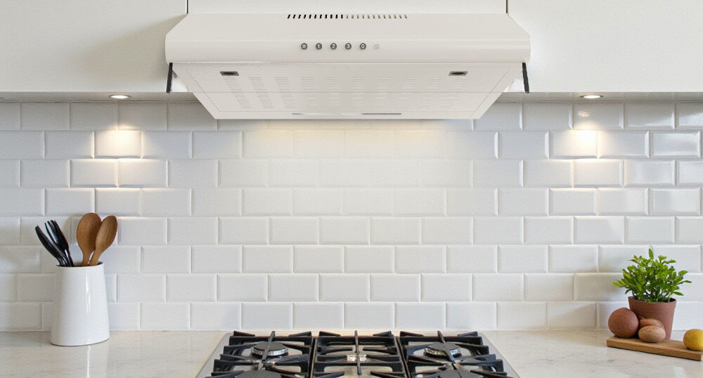 OKAP AKPO WK-7 ZK-60 Na zdjęciu znajduje się biały okap podszafkowy zamontowany nad płytą gazową, na tle białych, prostokątnych płytek ułożonych w cegiełkę. Po obu stronach płyty ustawiono akcesoria kuchenne, takie jak pojemnik z drewnianymi łyżkami i doniczka z rośliną, a światło z okapu równomiernie rozświetla całą strefę gotowania kolory elegancja wygląd styl