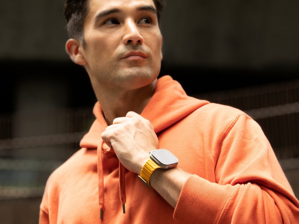 Pasek UNIQ Revix Evo do Apple Watch 1/2/3/4/5/6/7/8/9/SE/SE2/Ultra/Ultra2 (42/44/45/49 mm) Zielono-żółty, Zmieniaj styl, Mężczyzna eksponuje nadgarstek a na nim zegarek z paskiem