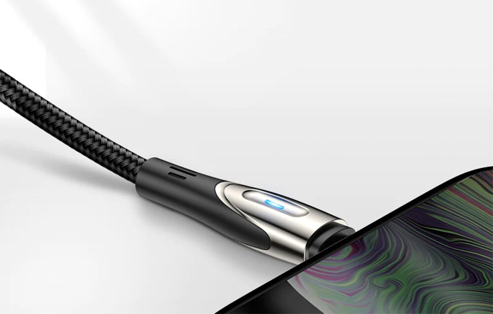 Na obrazie widać czarny kabel USB z metaliczną końcówką podłączony do urządzenia z kolorowym wyświetlaczem. Kabel ma plecioną osłonę i niebieski wskaźnik świetlny na złączu.