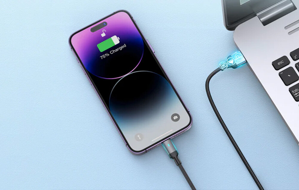 Smartfon z wyświetlaczem pokazującym ikonę ładowania i napis \'75% Charged\' jest podłączony do laptopa za pomocą kabla USB. Kabel ma biały kolor i jest podłączony do portu laptopa.