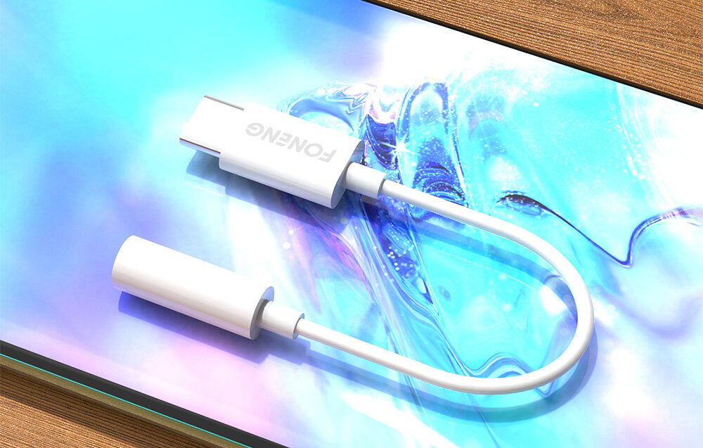 Biały kabel audio z końcówką 3.5mm Jack do USB typu C leży na kolorowym tle. Na adapterze widoczne jest logo \'FONENG\'.