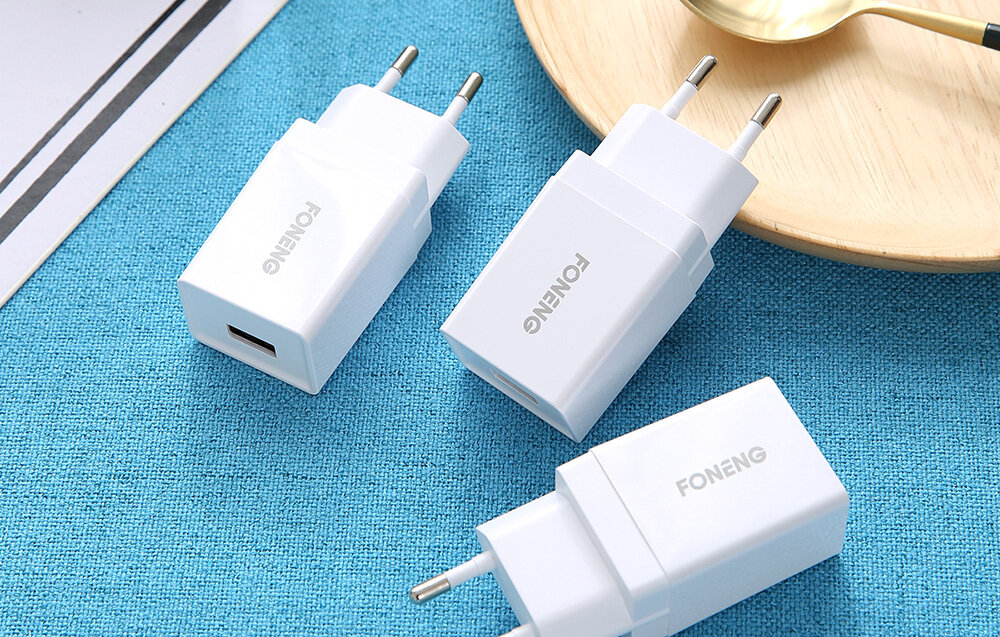 Na niebieskim tle znajdują się trzy białe ładowarki sieciowe z logo \'FONENG\'. Jedna z ładowarek ma widoczne gniazdo USB.