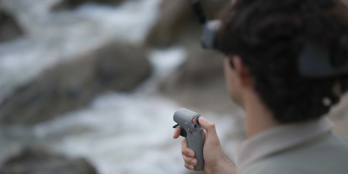 Mężczyzna trzymający kontroler DJI RC Motion 2.