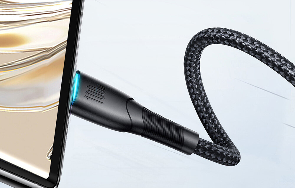 Czarny kabel USB-C z plecionym oplotem jest podłączony do urządzenia. Na wtyczce widoczny jest napis \'100W\'.