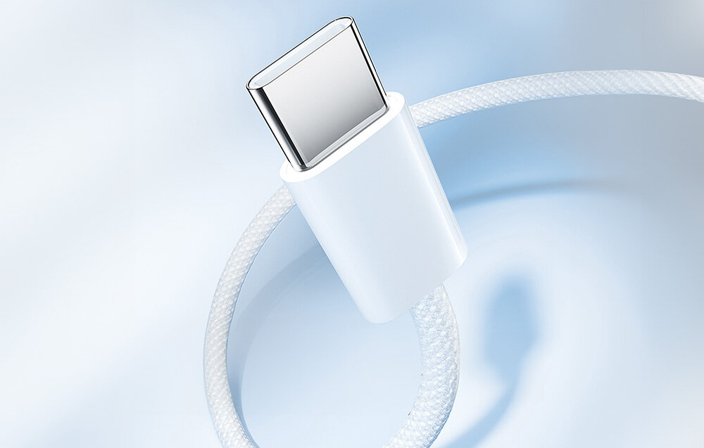 Biały kabel USB-C z oplotem, widoczny z bliska na jasnym tle.