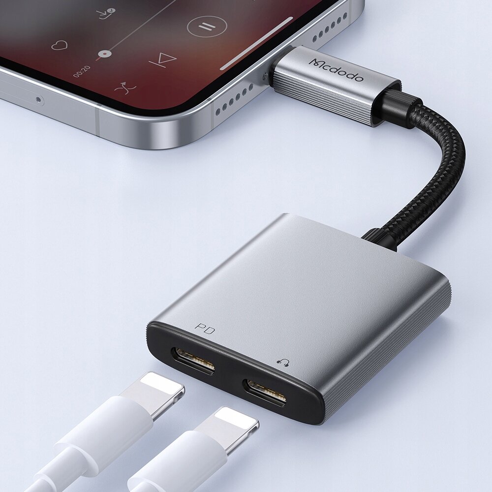 Na obrazie widoczny jest adapter z dwoma portami Lightning, podłączony do smartfona. Na adapterze znajduje się napis \'PD\' oraz logo \'Mcdodo\'.