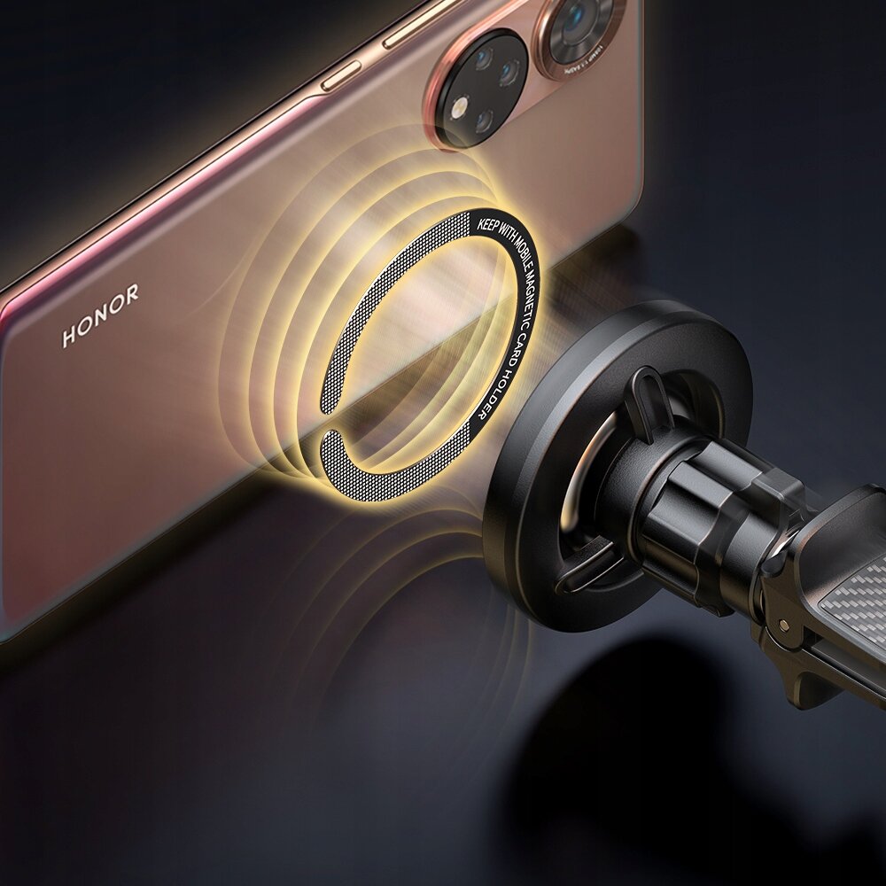 Obraz przedstawia telefon z logo \'HONOR\' zbliżający się do magnetycznego uchwytu samochodowego. Na uchwycie widoczny jest napis \'KEEP WITH MOBILE MAGNETIC CAR HOLDER\'.