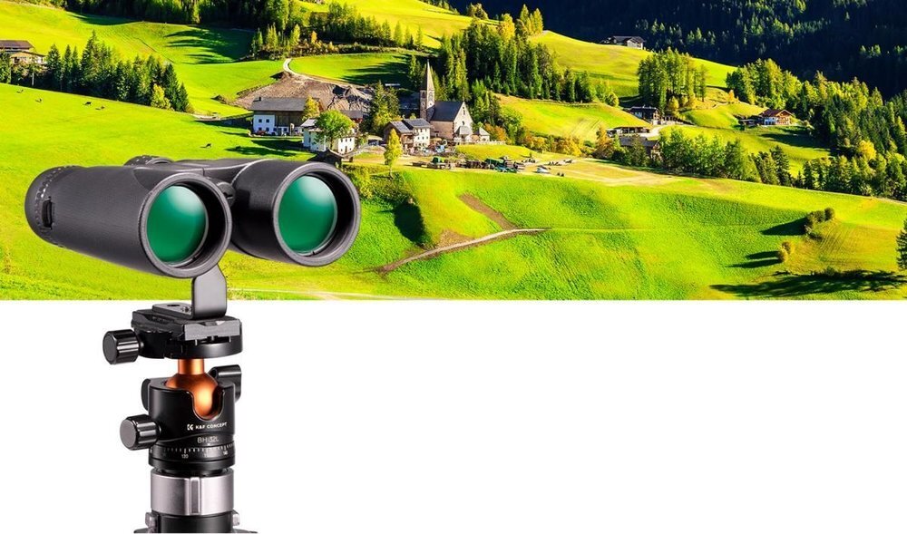 Na obrazie widoczna jest lornetka zamontowana na statywie, z widokiem na zielony krajobraz z wioską w tle. Na statywie znajduje się napis \'K&F CONCEPT\'.