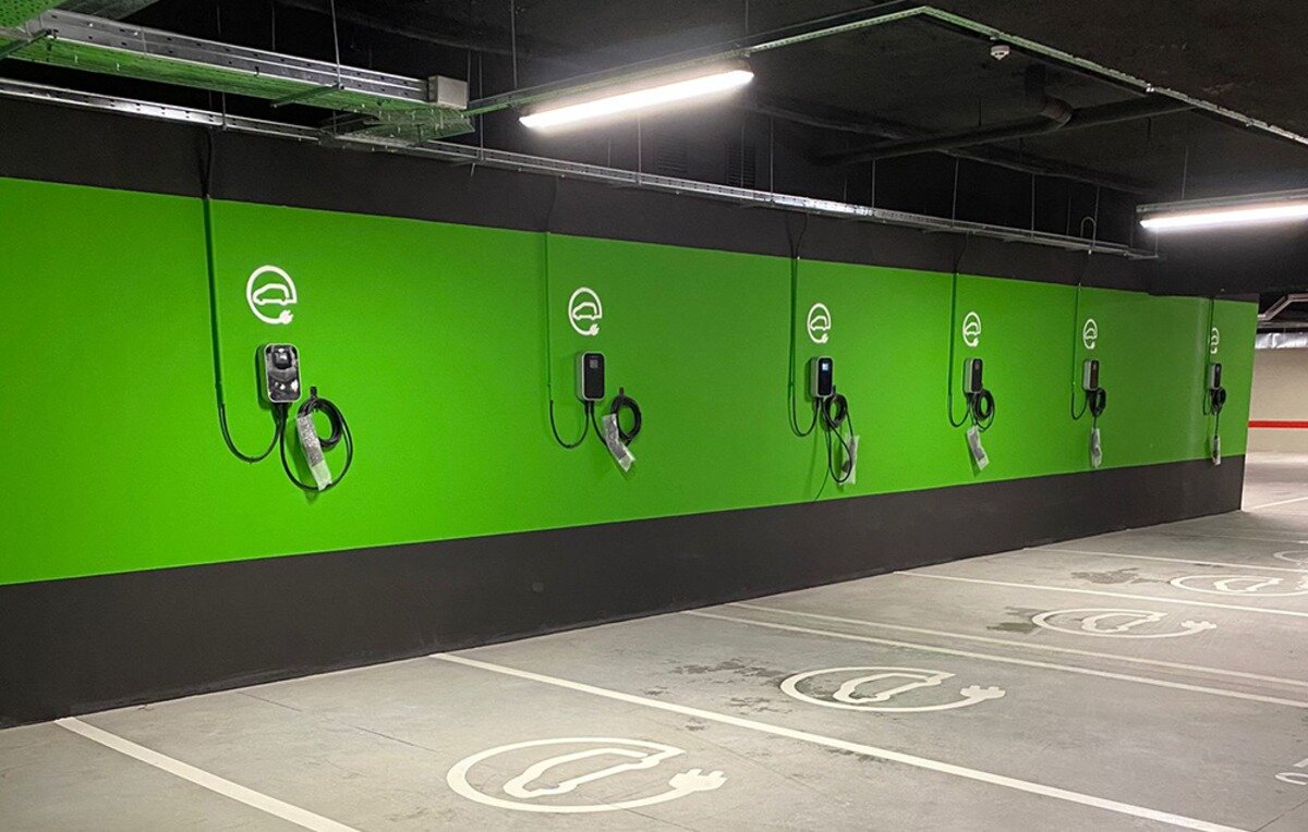 Ładowarka do samochodu elektrycznego BESEN BS20 App 22 kW Rząd ściennych ładowarek samochodowych zamontowanych na zielonej ścianie w garażu podziemnym