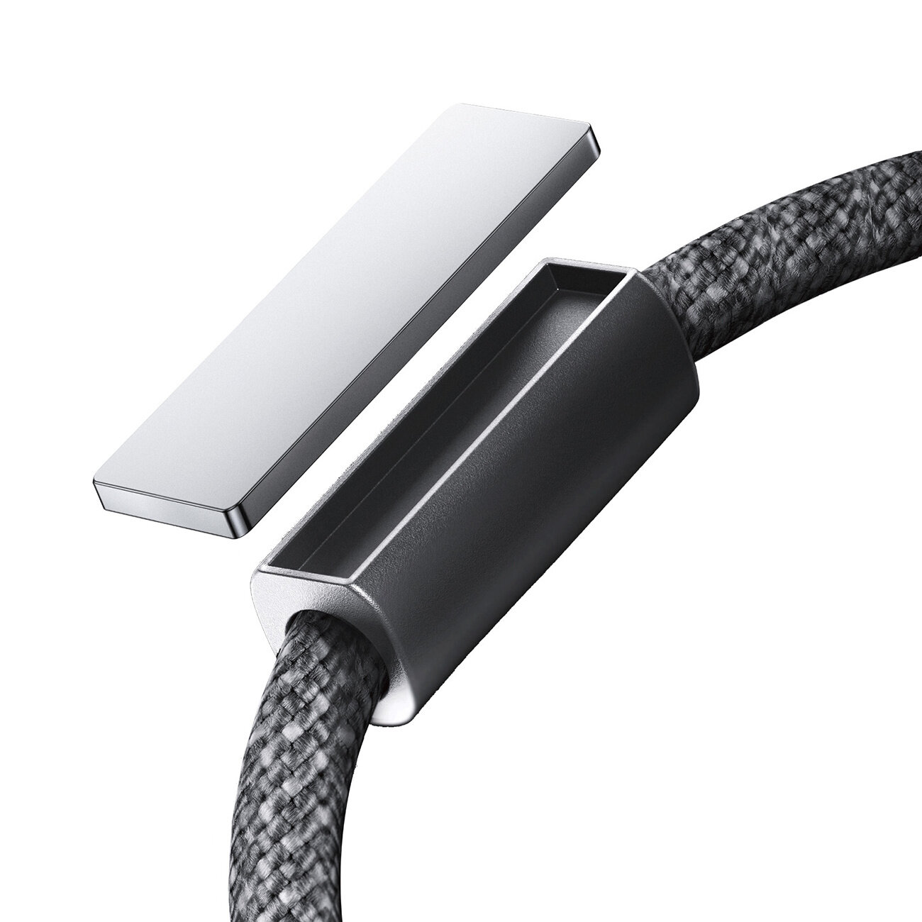 Obraz przedstawia szary kabel z plecionym oplotem oraz metalową końcówką. Obok znajduje się prostokątny, metalowy element.
