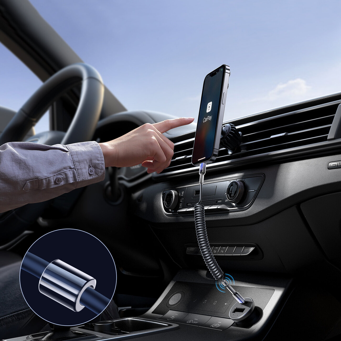Wnętrze samochodu z zamontowanym na kratce wentylacyjnej smartfonem, do którego podłączony jest spiralny kabel USB-C. Na ekranie telefonu widoczna jest ikona z napisem \'CarPlay\'.