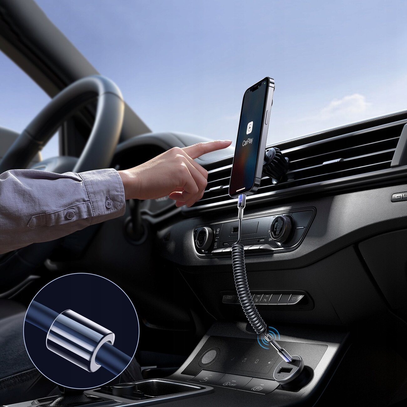 Wnętrze samochodu z zamontowanym telefonem na uchwycie, podłączonym spiralnym kablem USB-C do Lightning. Na ekranie telefonu widoczna jest ikona \'CarPlay\'.