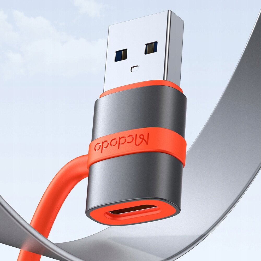 Na obrazie widoczny jest adapter USB z metaliczną obudową i pomarańczowym akcentem, z napisem \'mcdodo\'.