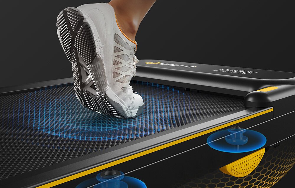 Bieżnia elektryczna UREVO Strol 2E Smart 2w1 550W 10km-h osoba korzysta z bieżni zbliżenie na pas biegowy pokazana miejsca z amortyzacją zaawansowany, 5-warstwowy pas biegowy 2 miękkimi poduszkami 8 silikonowymi amortyzatorami redukuje wstrząsy zmniejsza się obciążenie stawów, kolan i kręgosłupa