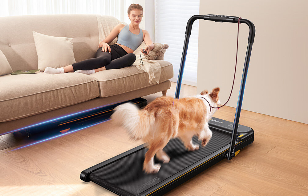 Bieżnia elektryczna UREVO Strol 2E Smart 2w1 550W 10km-h pokój osoba leży na kanapie pod kanapą leży bieżnia obok na drugiej bieżni chodzi pies konstrukcja 2w1 w formie klasycznej bieżni do biegania wersji biurkowej do spokojnych spacerów prędkość od 1 do 10 km/h wymiary 57.3 x 98.7 x 122 cm waga około 21,4 kg